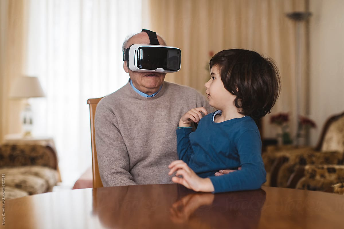 Grandfather with his grandson using virtual reality glasses