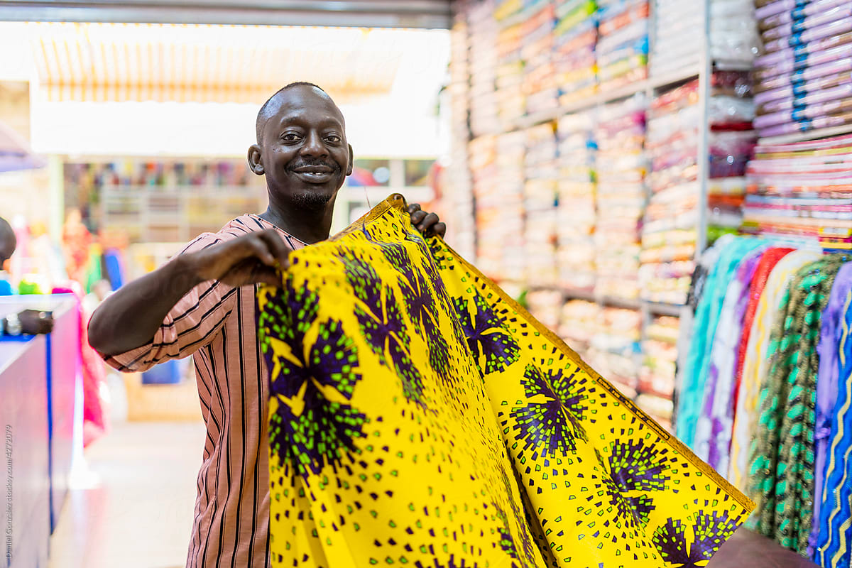 Black man folding bright fabric