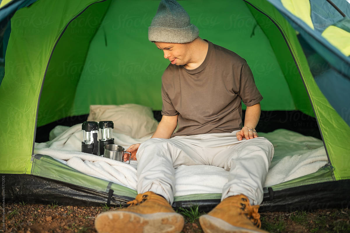 man with down syndrome inside a tent with flashlights