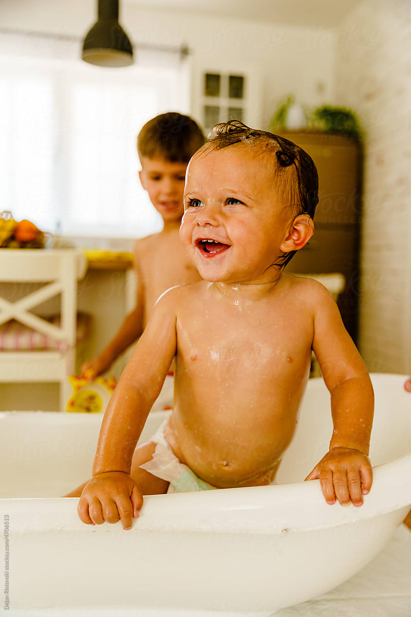 Cheerful wet baby boy bathing
