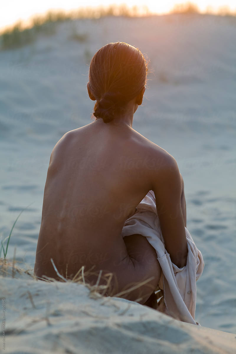 nude woman sitting  on beach