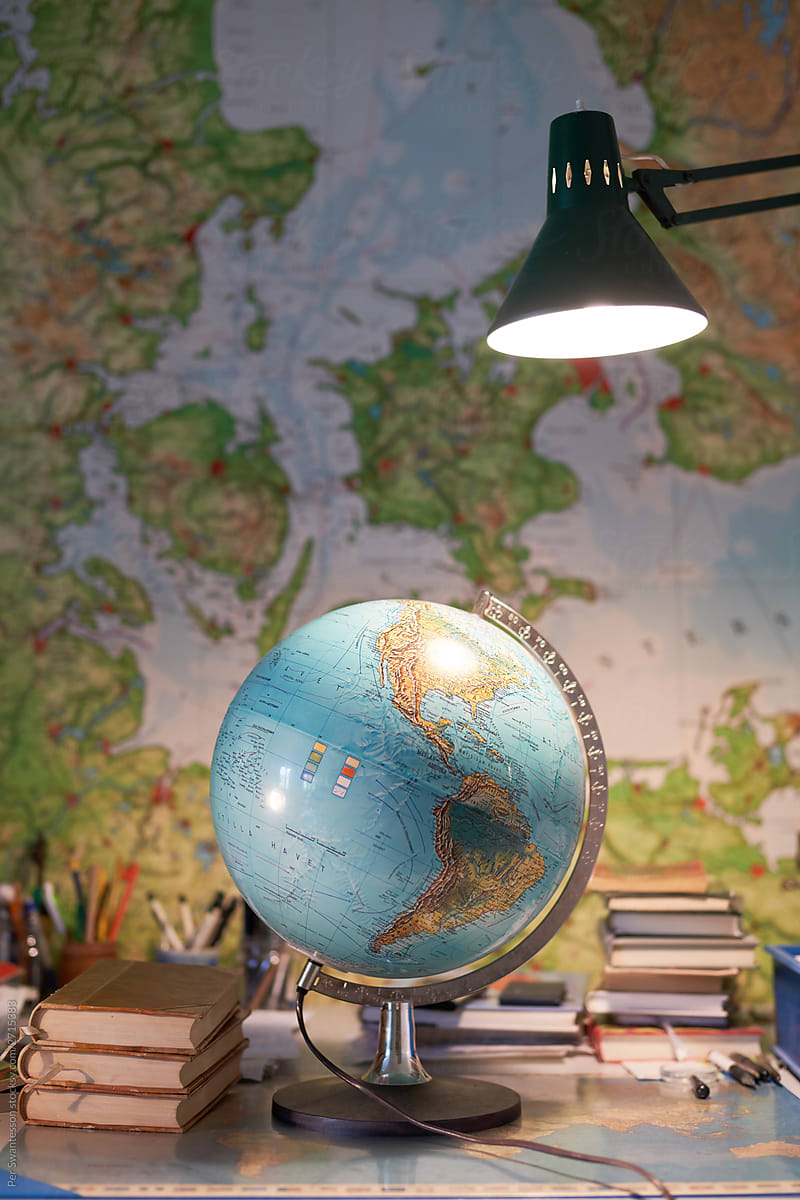 Travel concept with map: World map globe on a desk. Travel map on wall