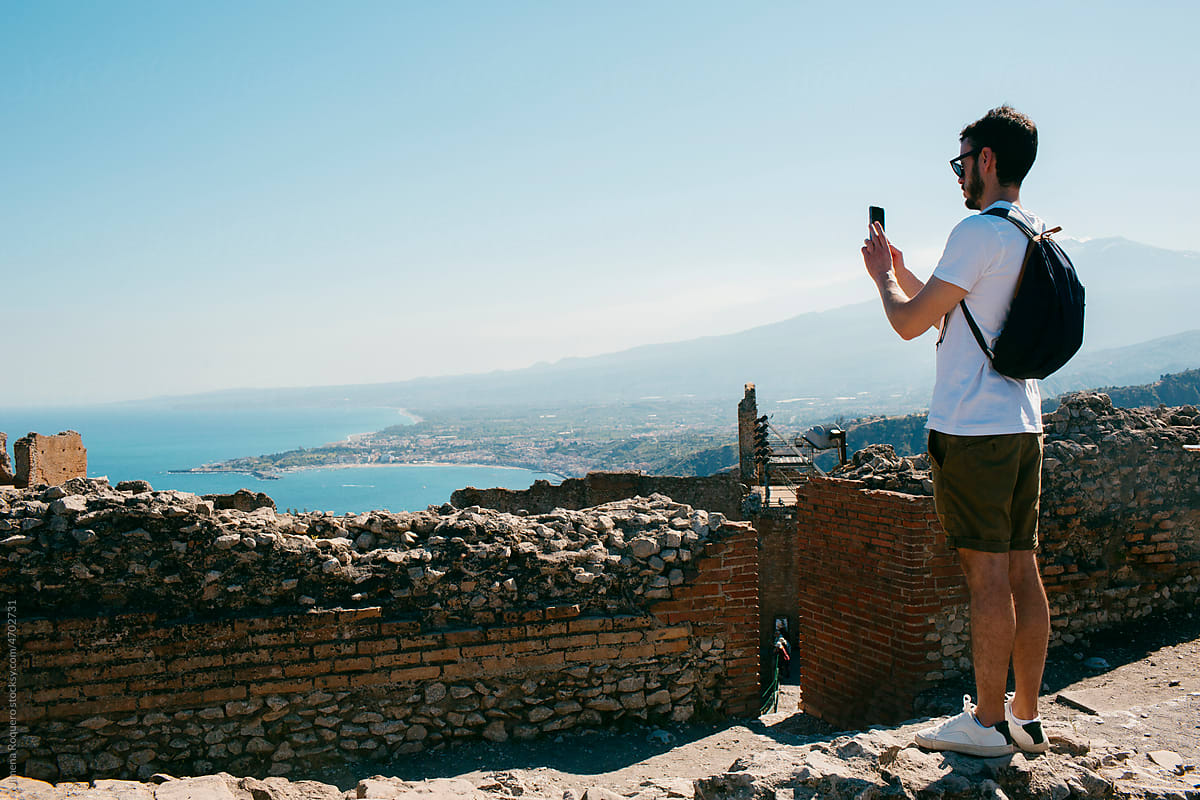 Tourist taking pictures from ancient ruins of the views of the sea