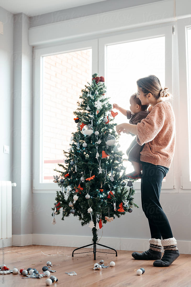 Mom and baby decorating Christmas tree