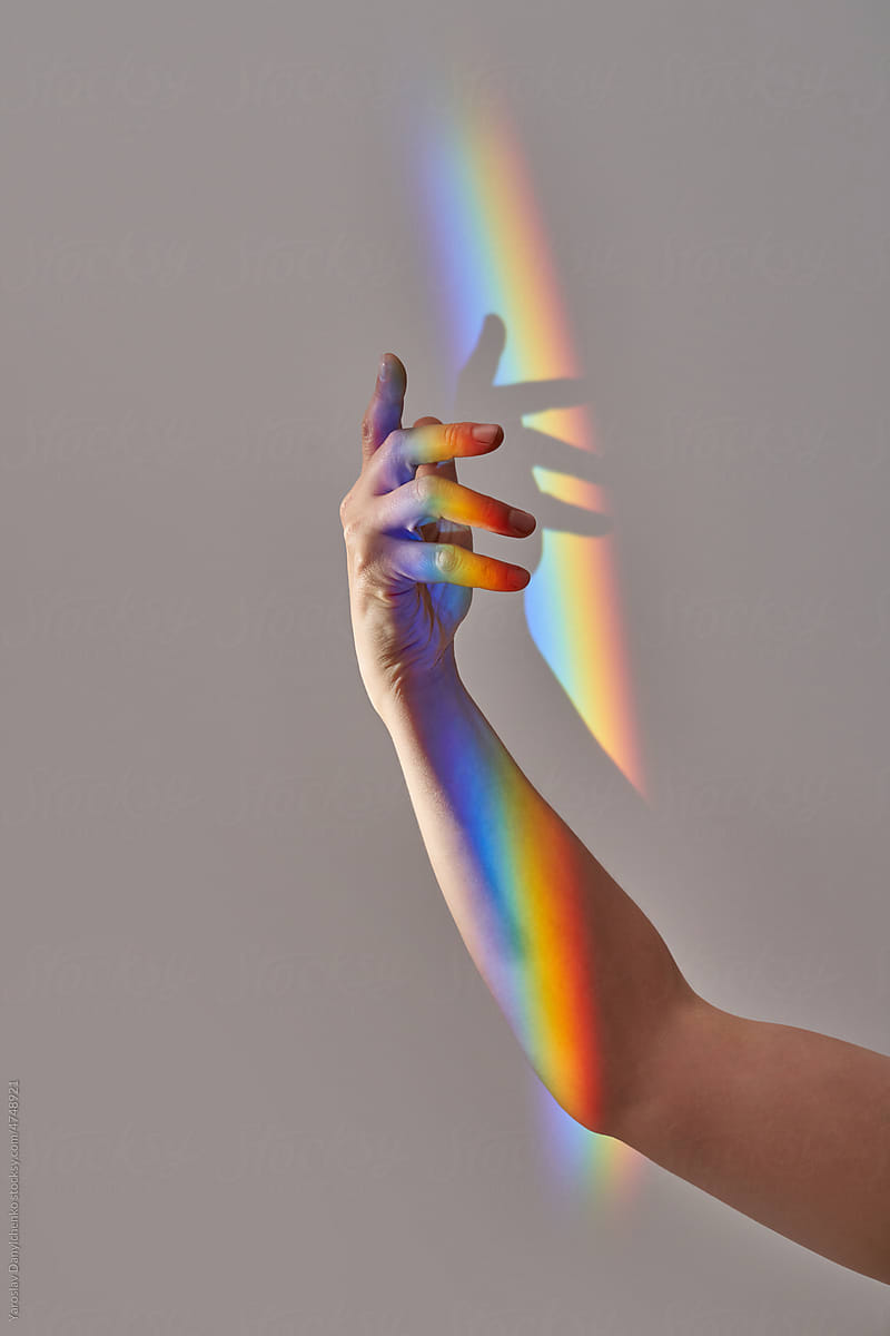 Woman\'s hand with rainbow light.