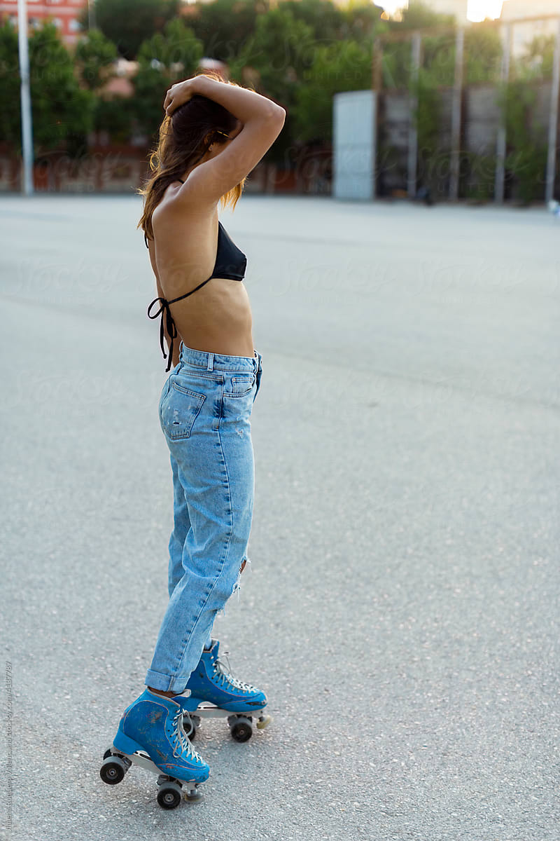 Profile of fit stylish roller skater girl in sunlight