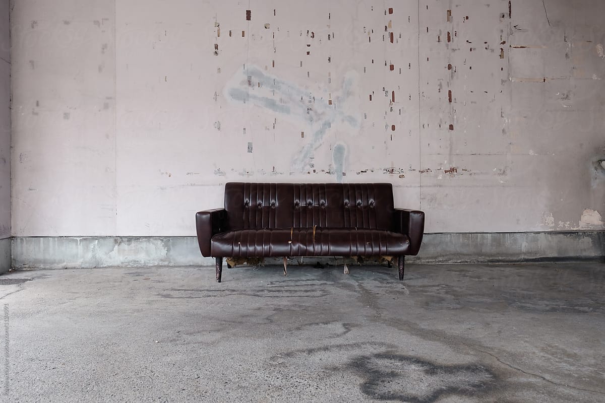 Old Vinyl Sofa in a concrete garage