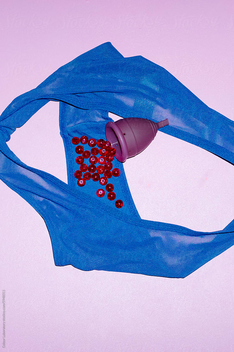 Contemporary photo of underpants and period cup and blood with flash