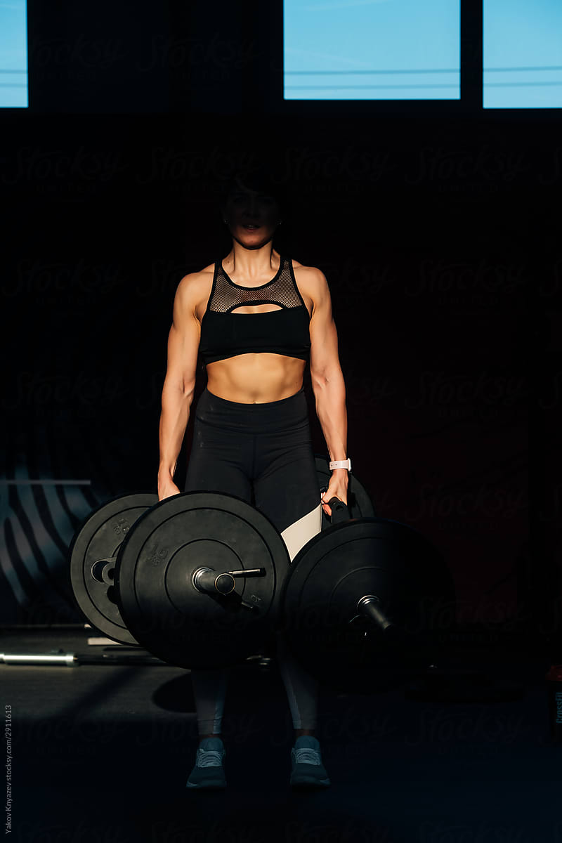 Crossfit athlete - young beautiful woman doing deadlifts with a trap multi grip bar