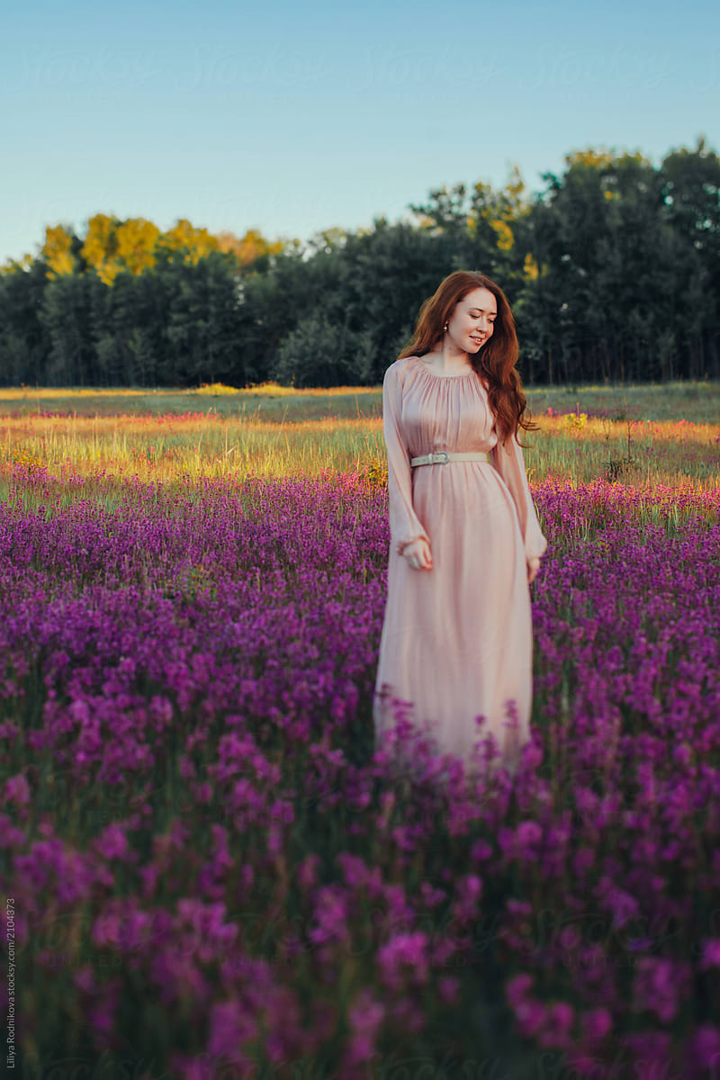 Woman posing among violet flowers