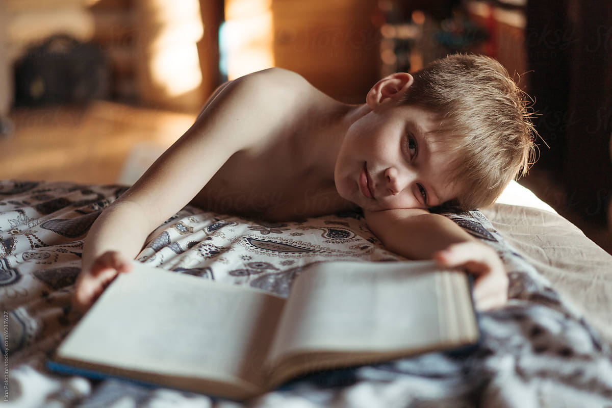 Boy Reading Book in Cozy Bedroom Light