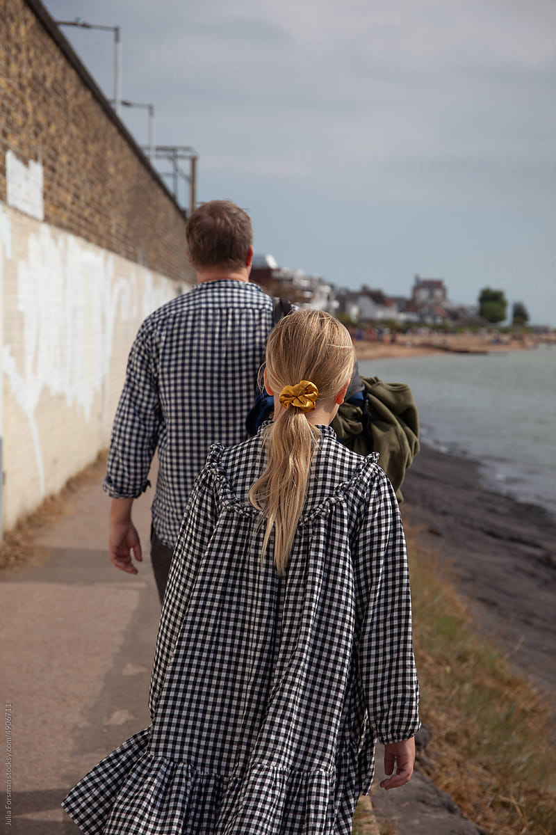 Father and daughter walk towards Chalkwell in the Essex coast.