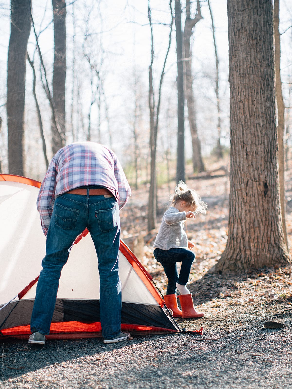 Father and daughter set up a tent on a camping trip