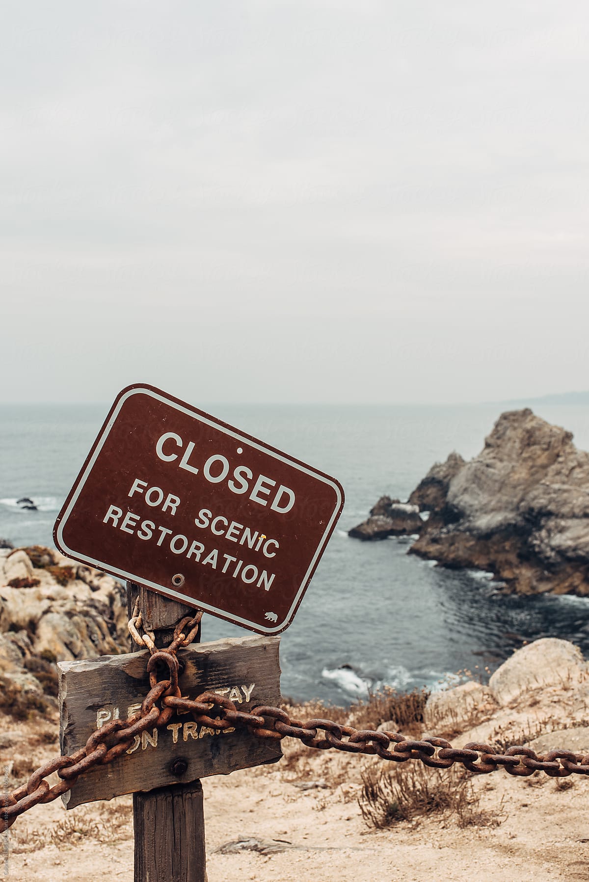 Sign showing Closed For Restoration by an ocean cliff