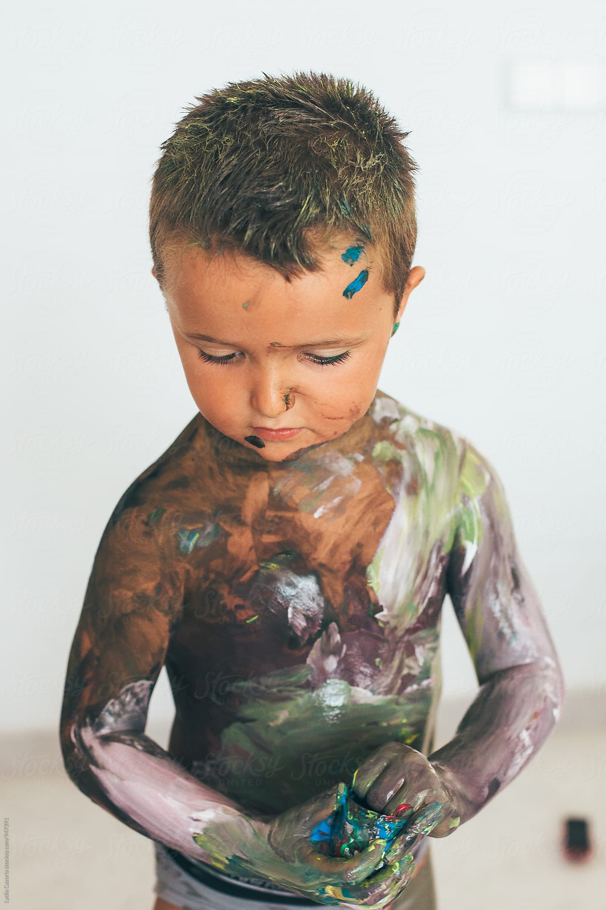 Playful child covered in paint