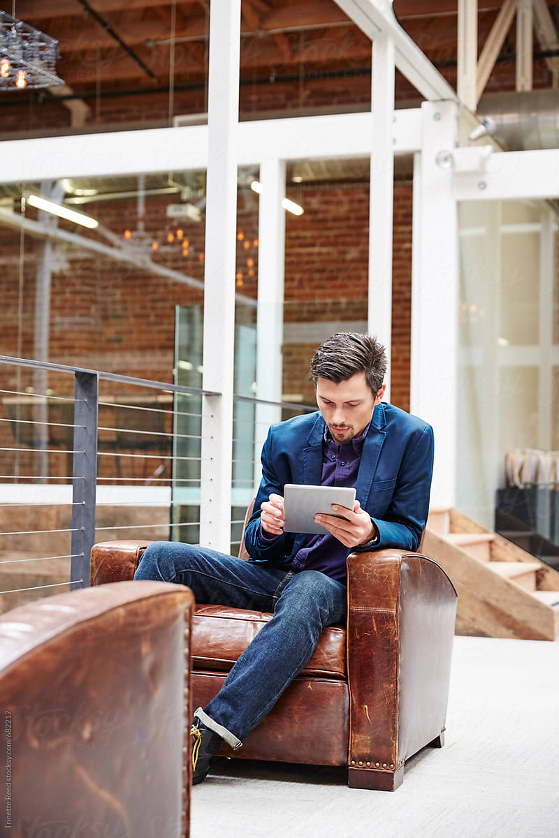 Millennial businessman using digital tablet at office