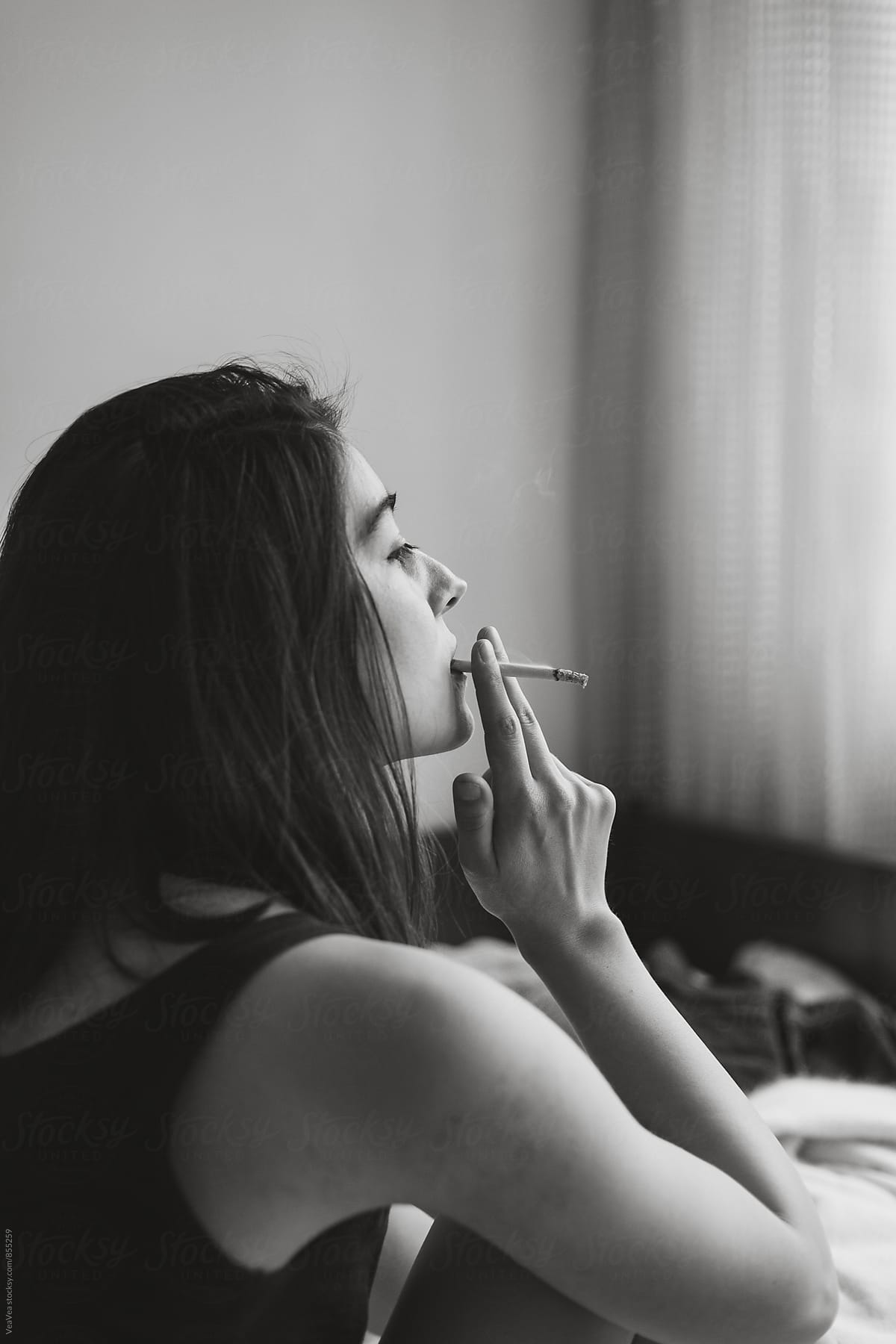 Beautiful woman smoking a cigarette indoor