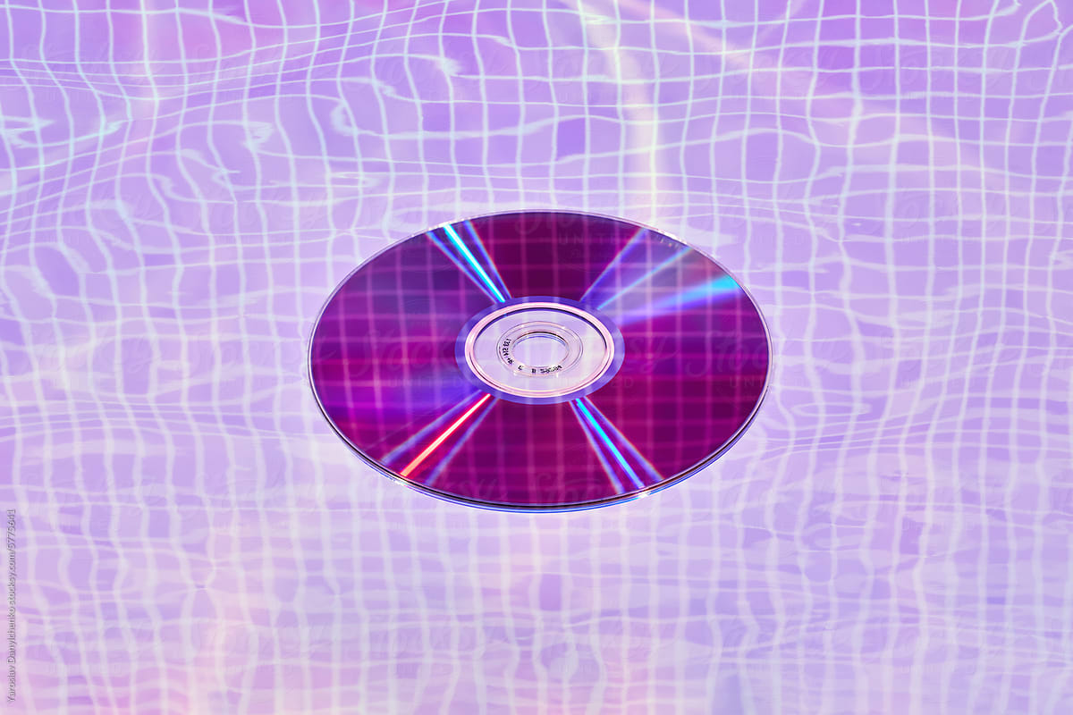 Single CD disc placed under water with violet neon light