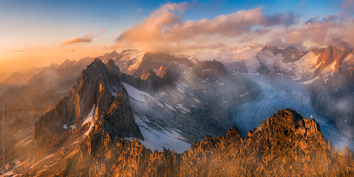 Man standing on swiss alpine ridge sunset panorama