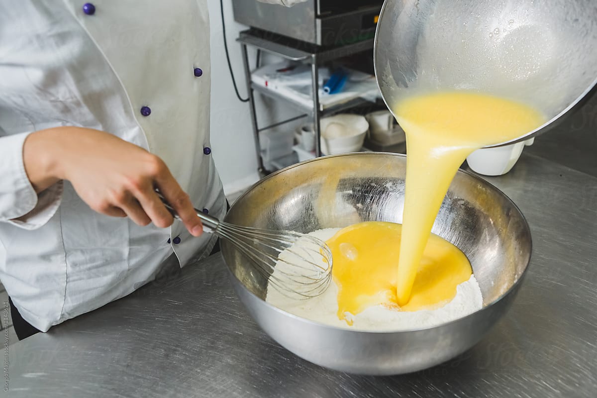 Pastry Chef Pouring Batter a Bowl Full of Flour