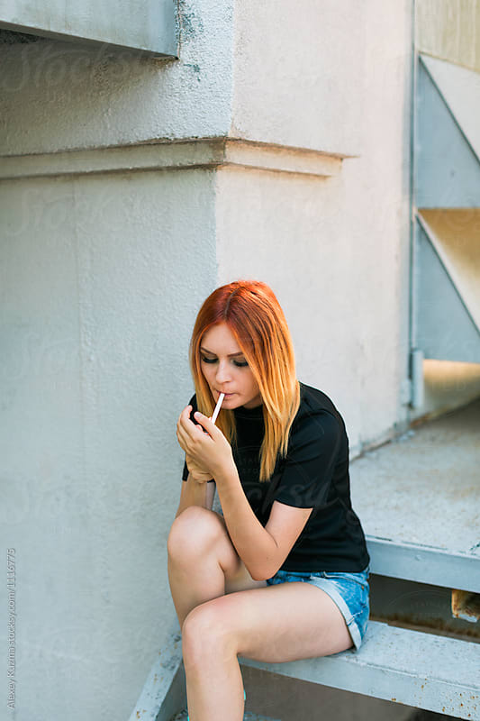 young woman smoking on the street
