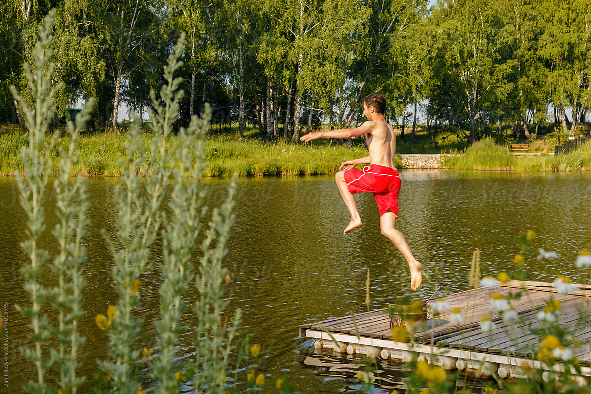 Adult male swimmer leaping into river water
