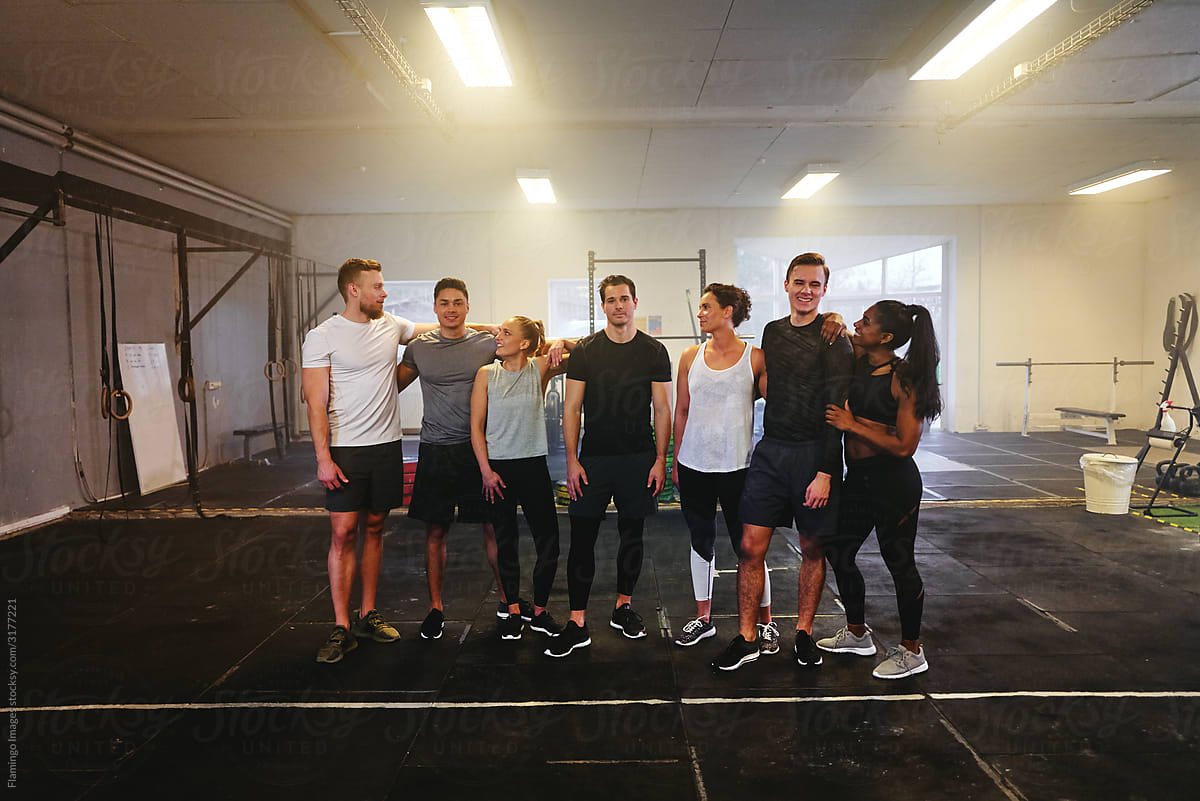 Smiling group of fit young people talking in a gym
