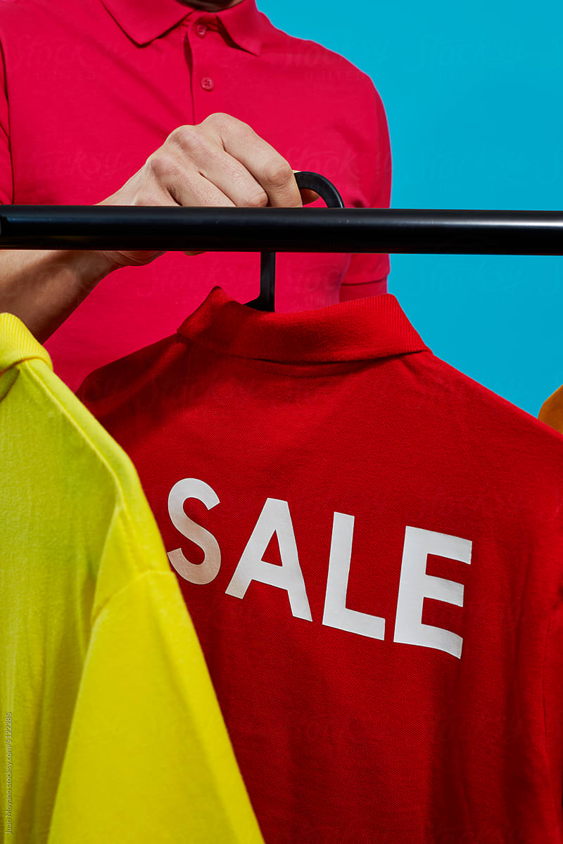 man takes a red t-shirt with the word sale