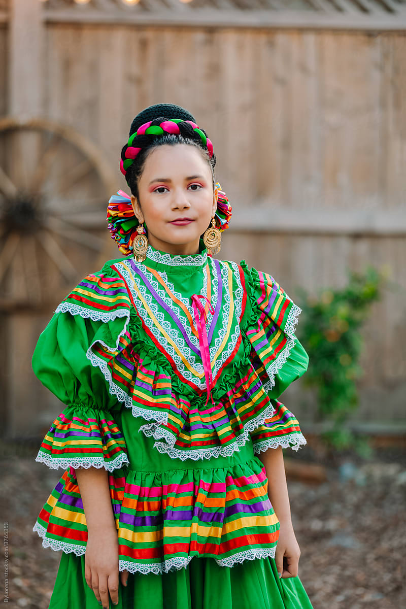 Portrait girl dressed up with a traditional Mexican dress and braid hairstyle