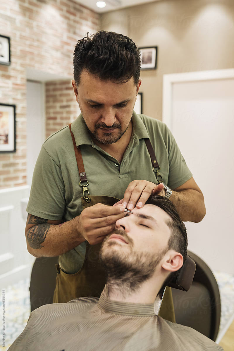 Barber trimming eyebrows