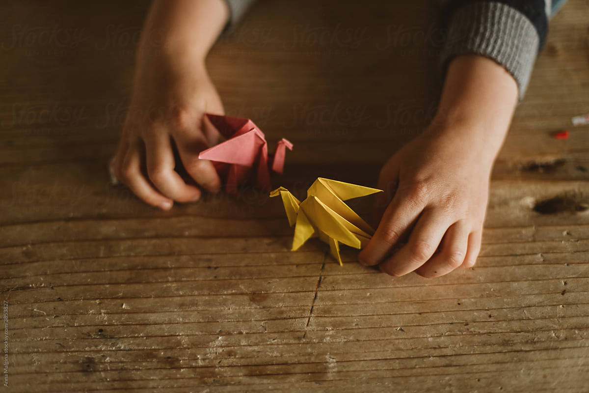 Origami dragon battle with kid\'s hands