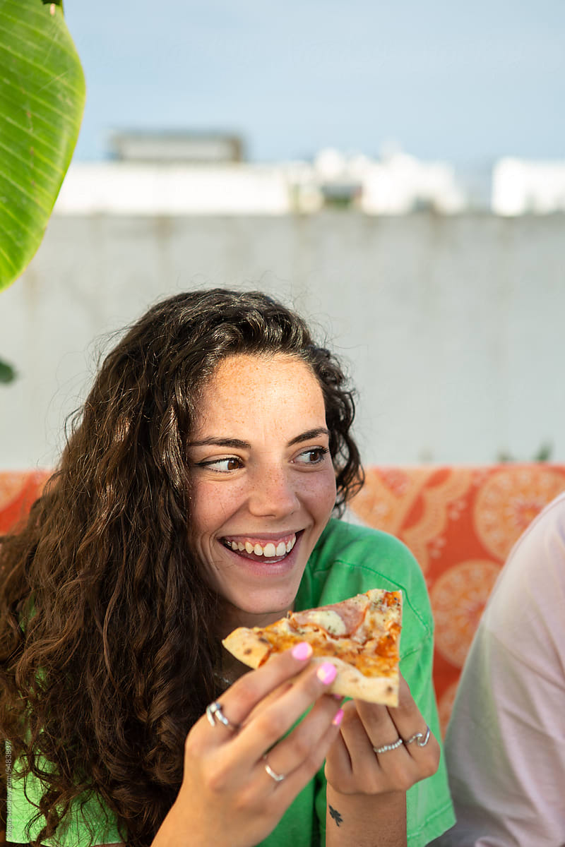 Young woman smiling with pizza