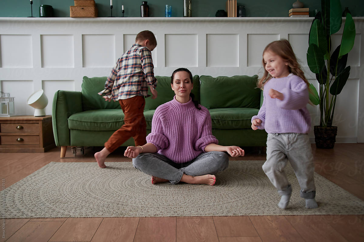 Children run around the mother in the lotus position