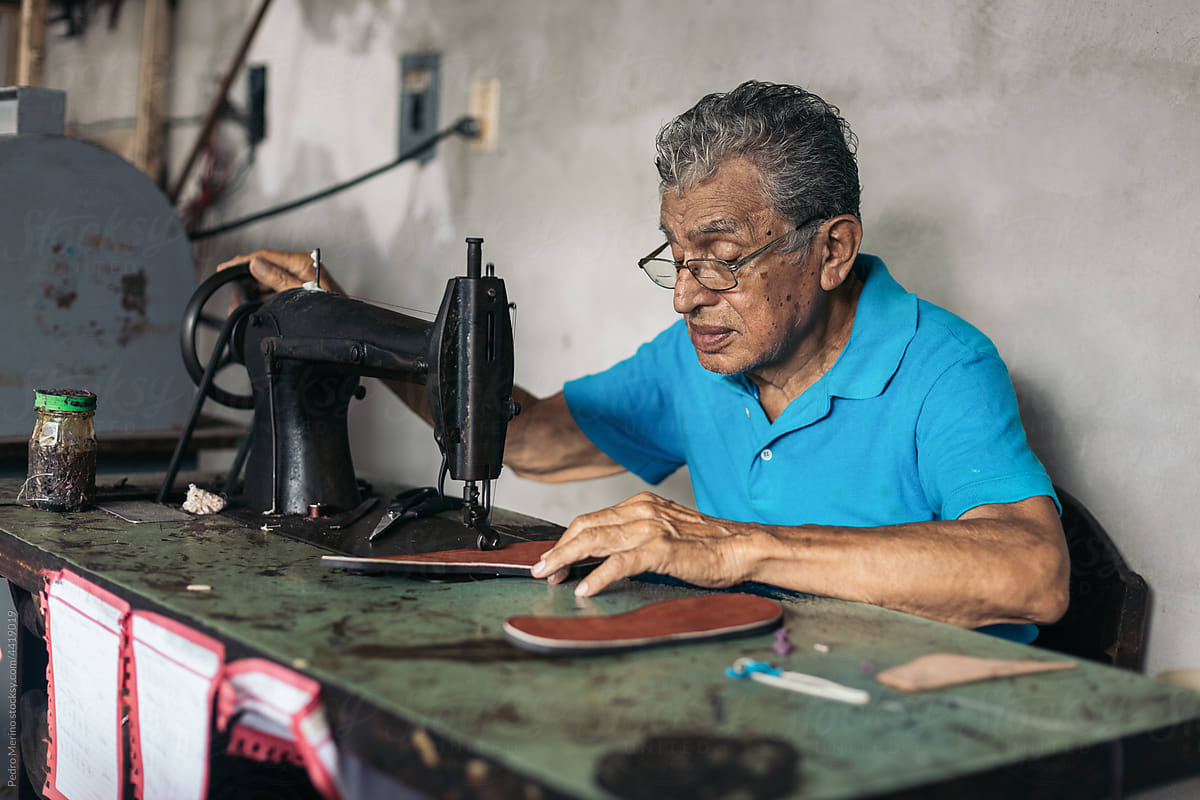 Older shoemaker working in his workshop