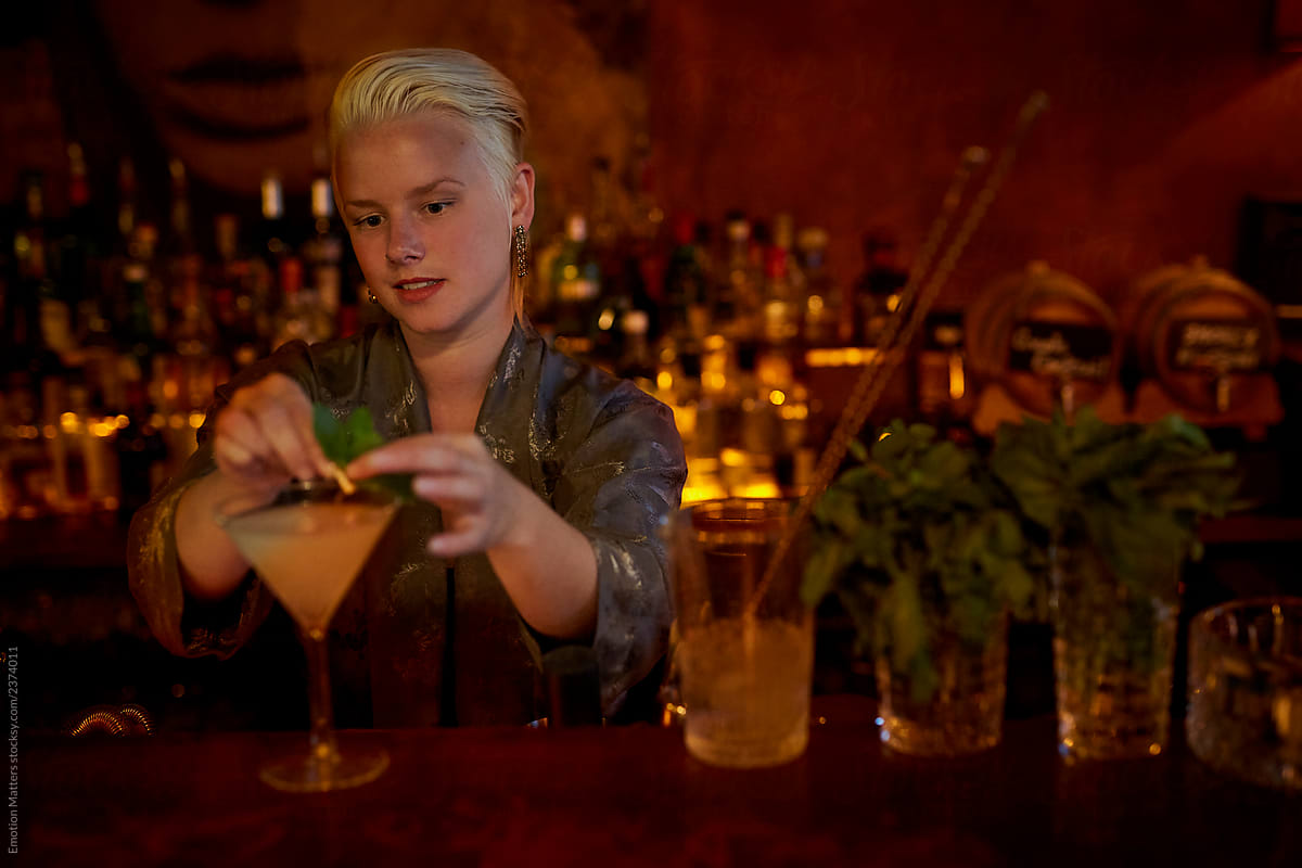 A bartender putting garnishes on a drink