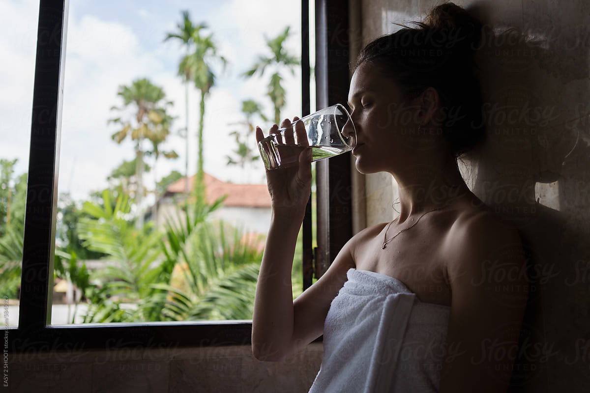 Woman in Towel Drinking Water From Glass