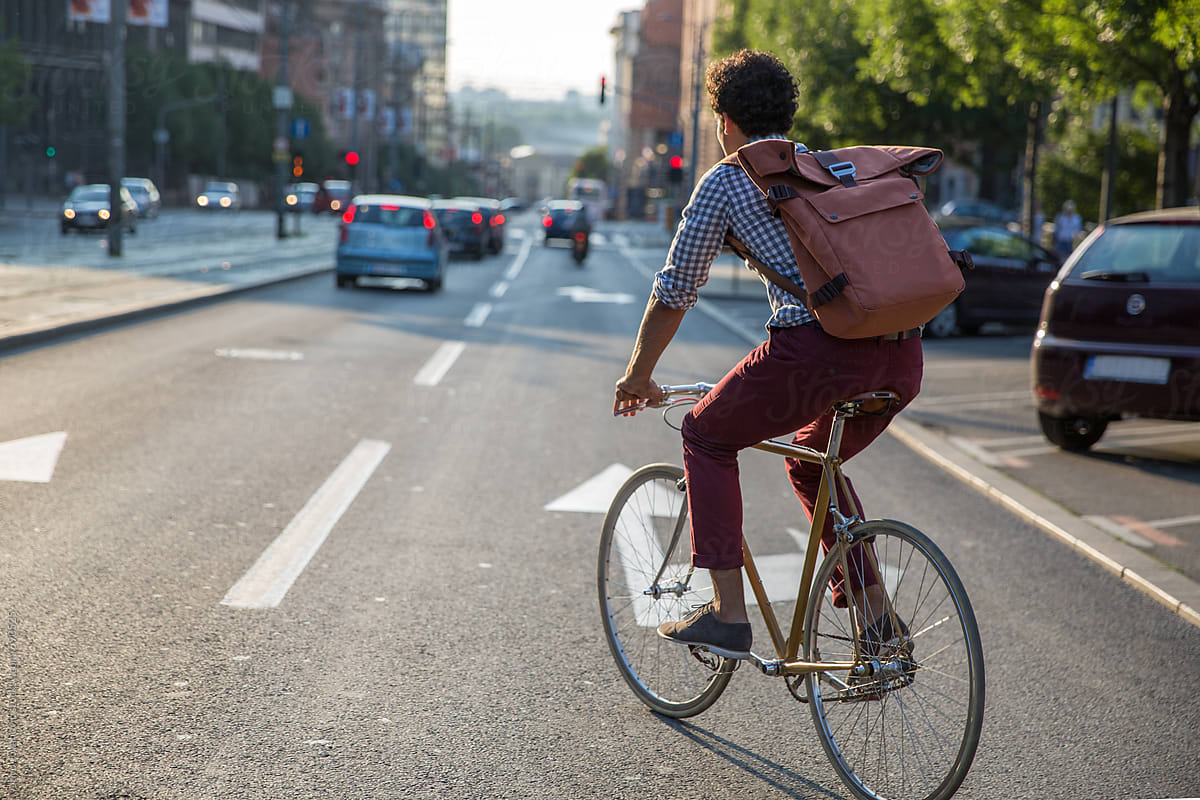 Stylish Man Riding A Bike Outside To Work With Backpack By Stocksy Contributor Jovo Jovanovic