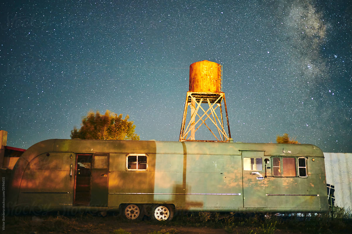 Abandoned 50s home trailer in US at night.