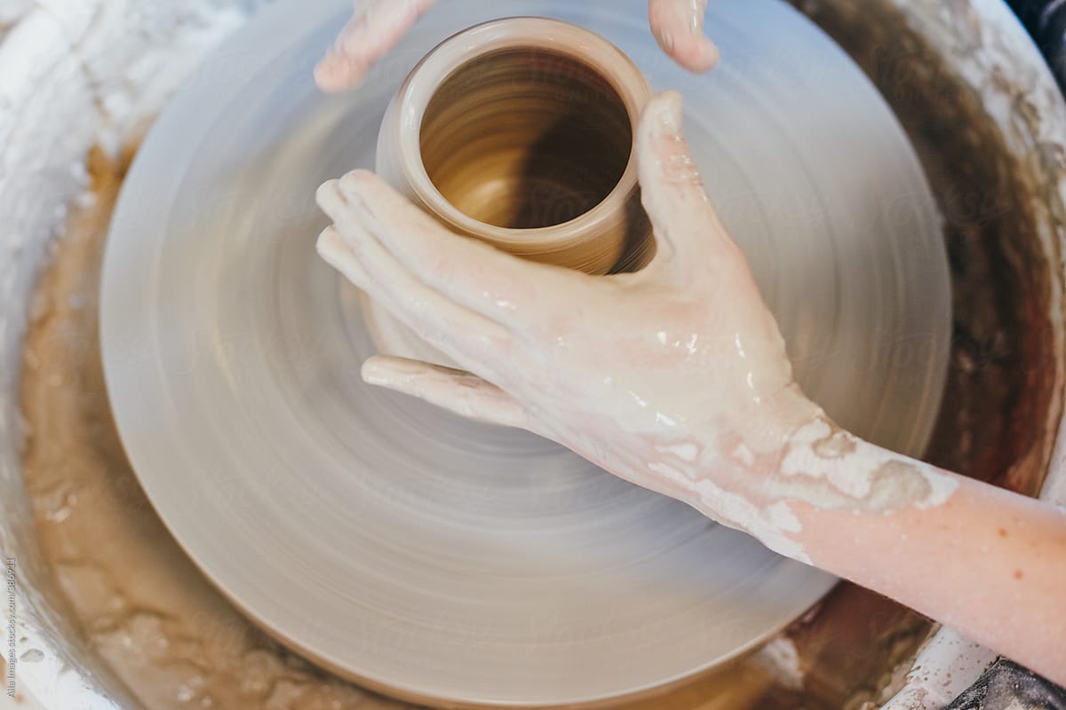 Dirty potter\'s hands making a ceramic just on a turning wheel