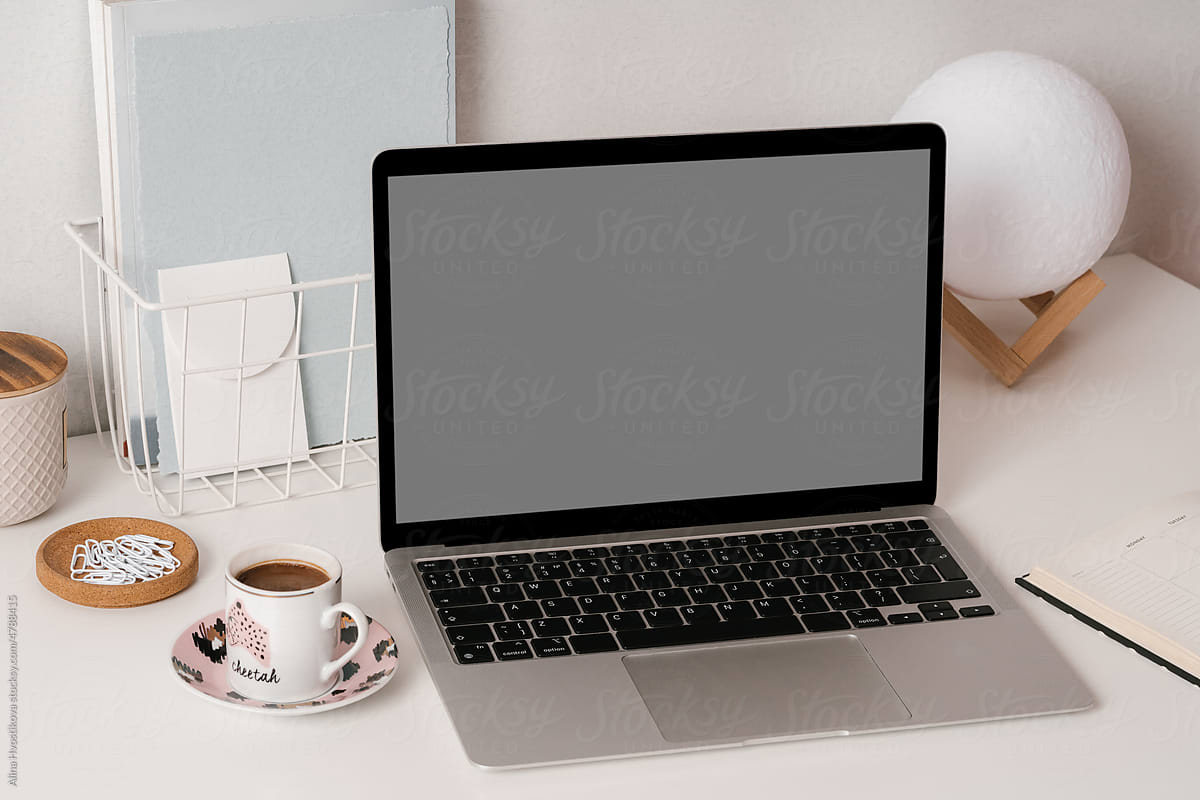 Netbook with planner and coffee cup on desk