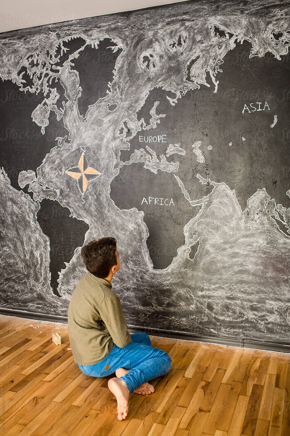 Boy drawing world\'s map in the classroom
