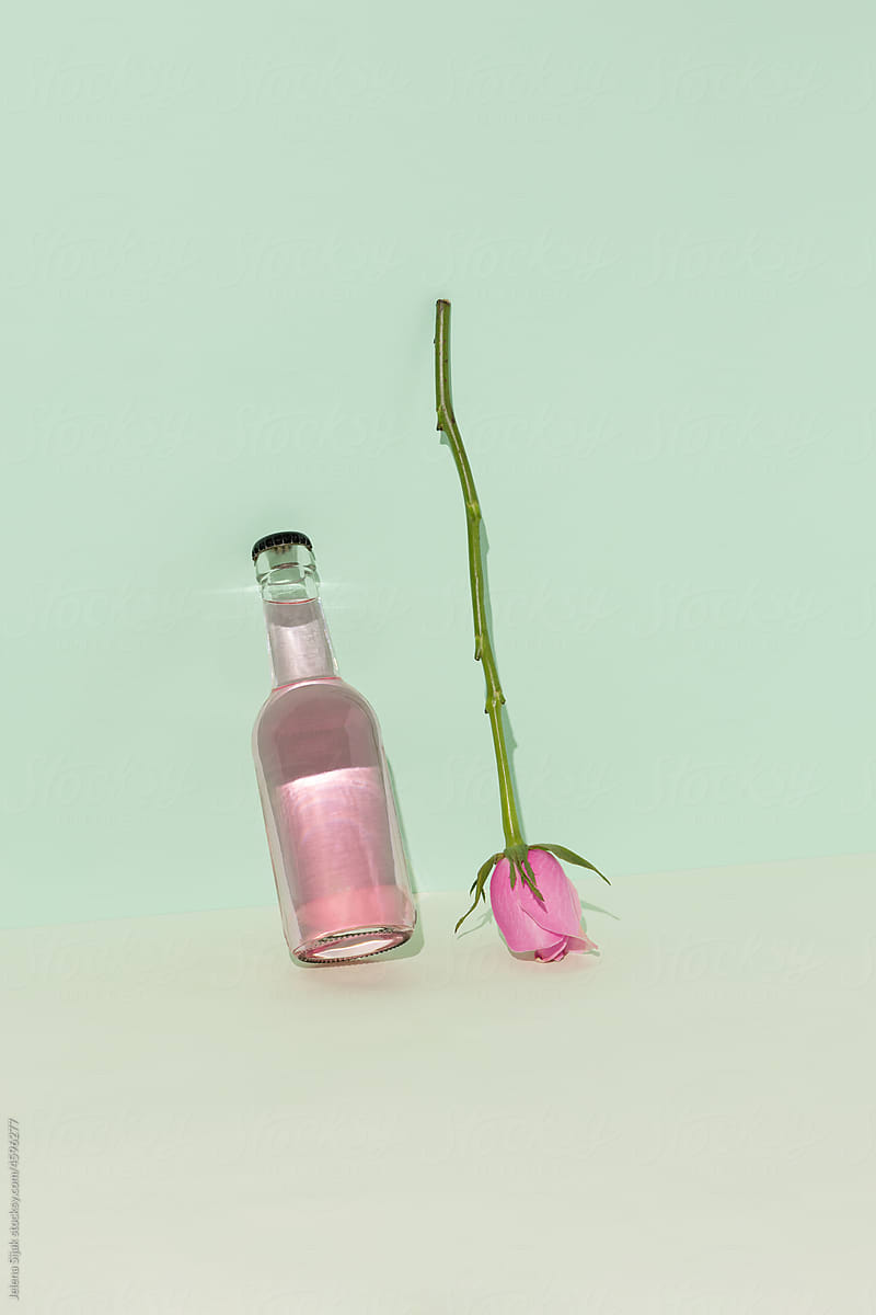 Pink refreshing summer drink in bottle with a rose, alcoholic coctail