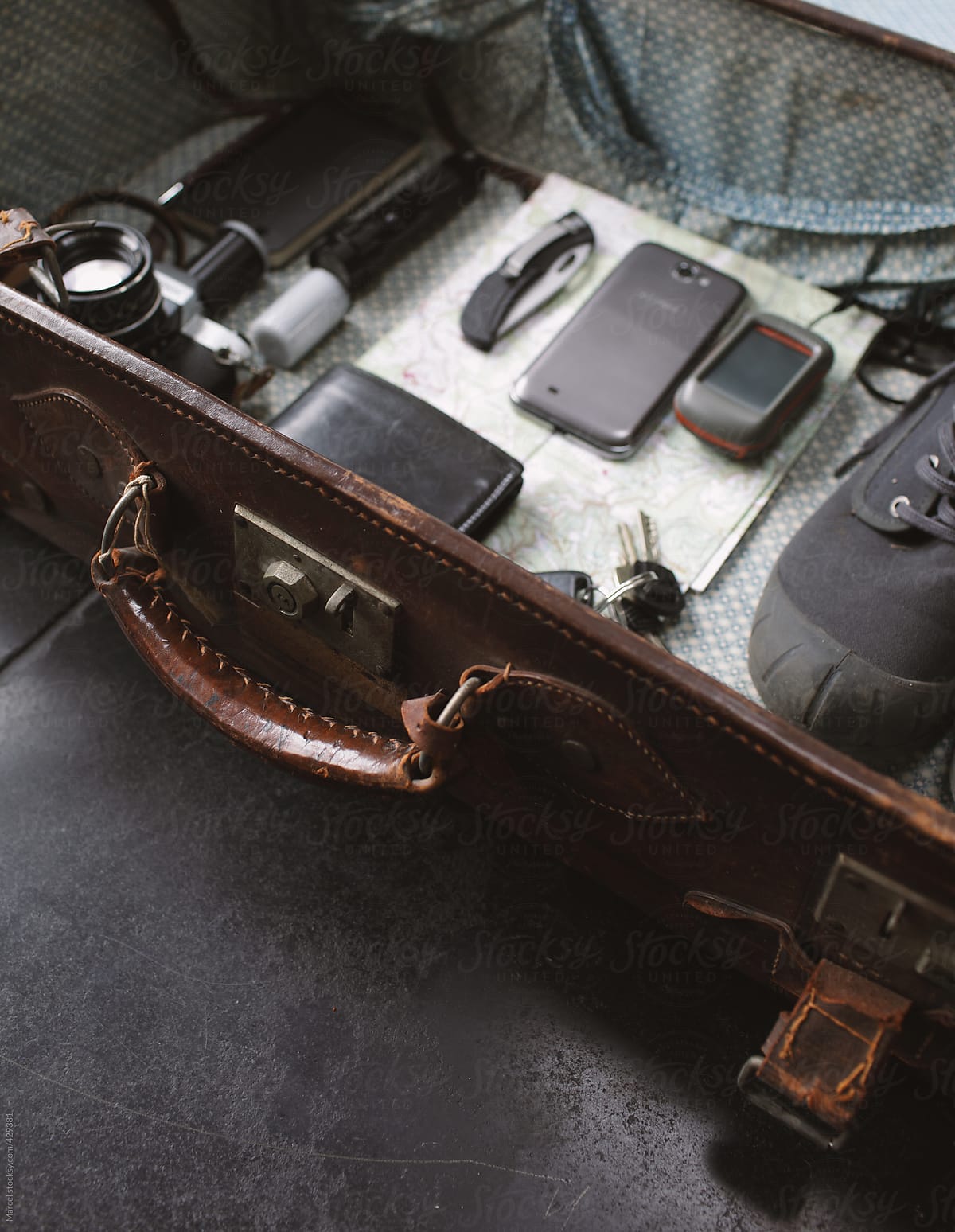 Old leather suitcase packed with travel gear