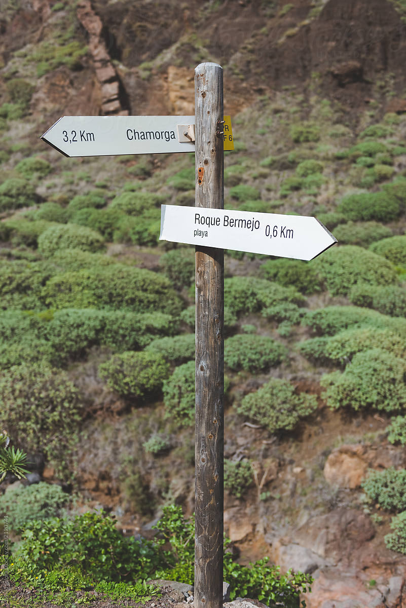 Wooden two arrow direction sign post in the mountains
