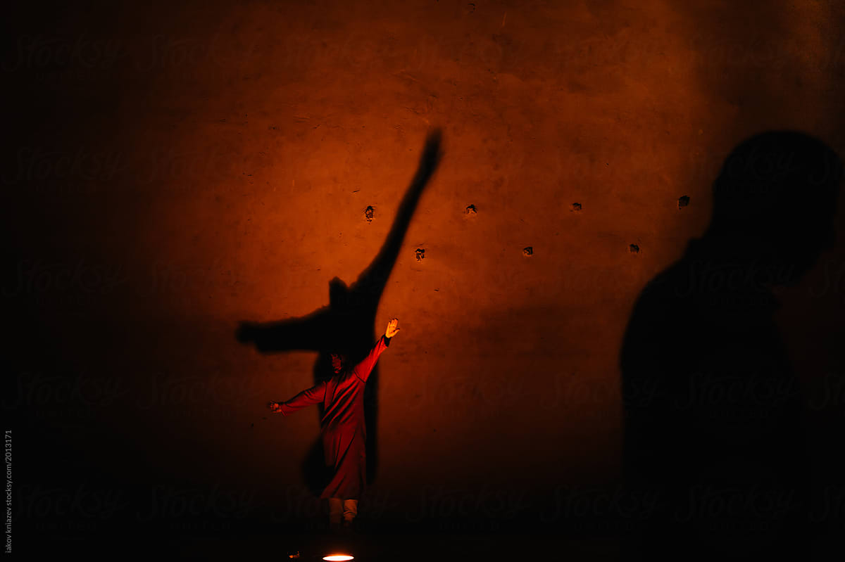 Woman dances against a backlit wall in Morocco