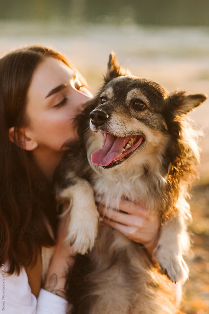 Girl kissing cute dog outdoor