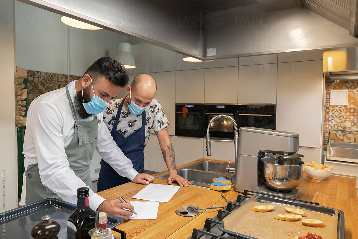 Chefs Working In Menu With Mask