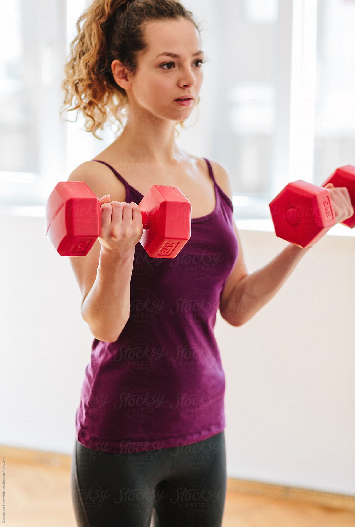 Young woman making excercises with dumbbells
