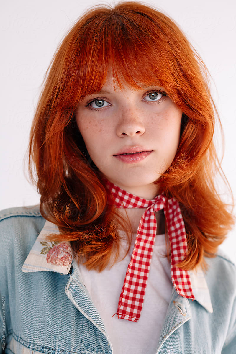 Charming girl with red hair closeup portrait in studio