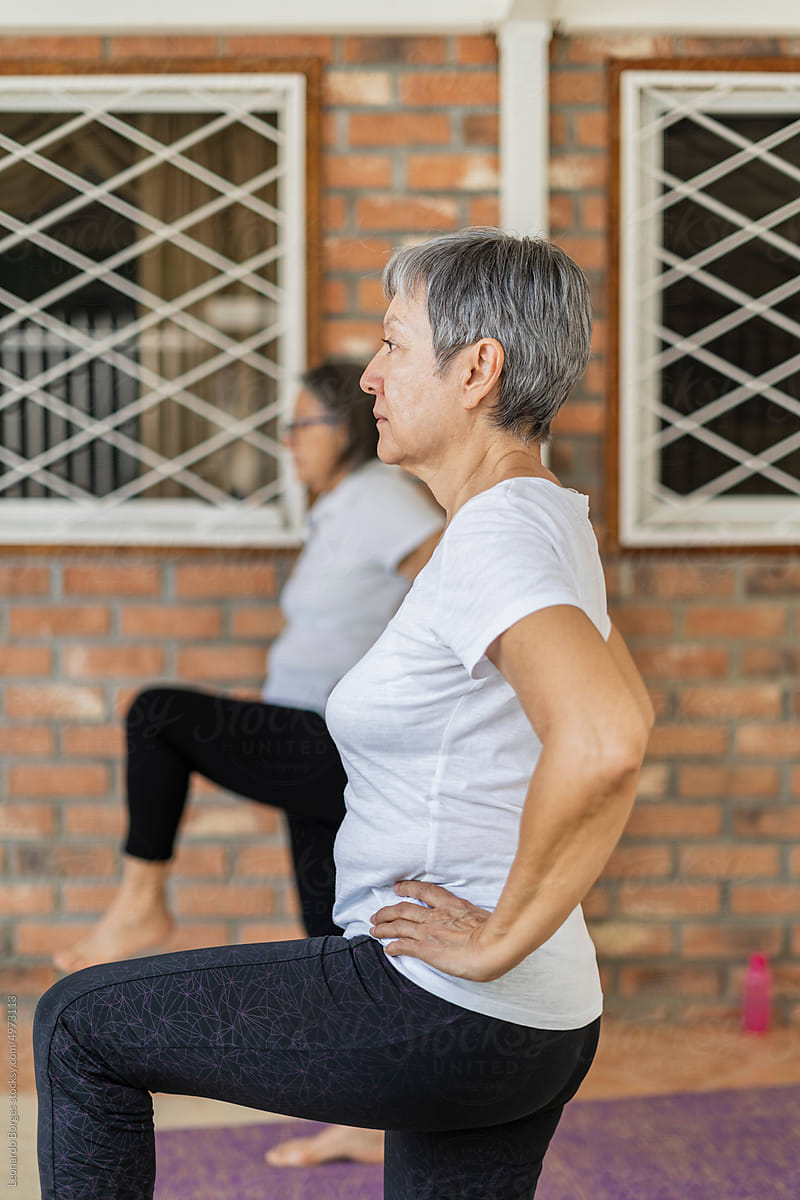Older adult performing yoga positions standing